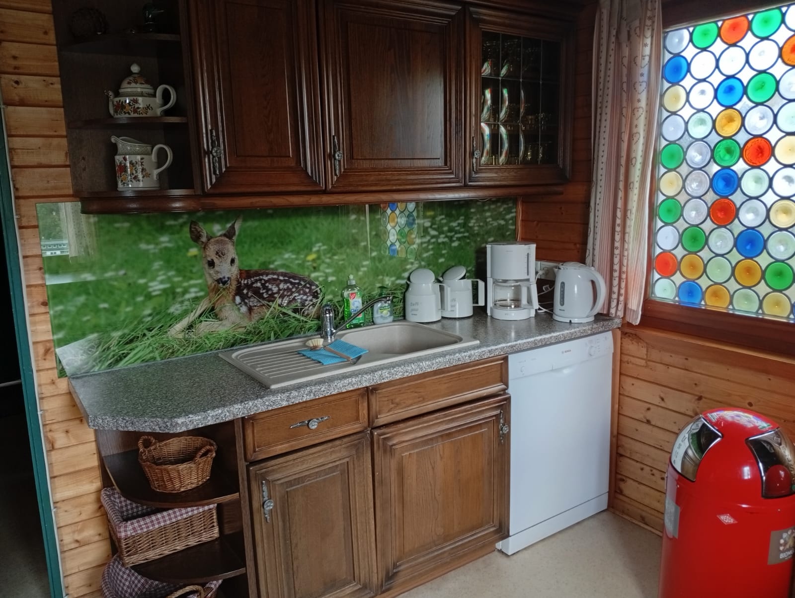 Küche mit Spülbecken und dekorativer Rehkitz-Rückwand