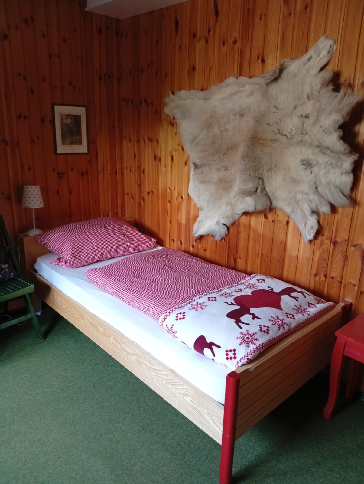 Schlafzimmer 1 im UG mit gemütlichem Bett und Jagdhaus-Deko