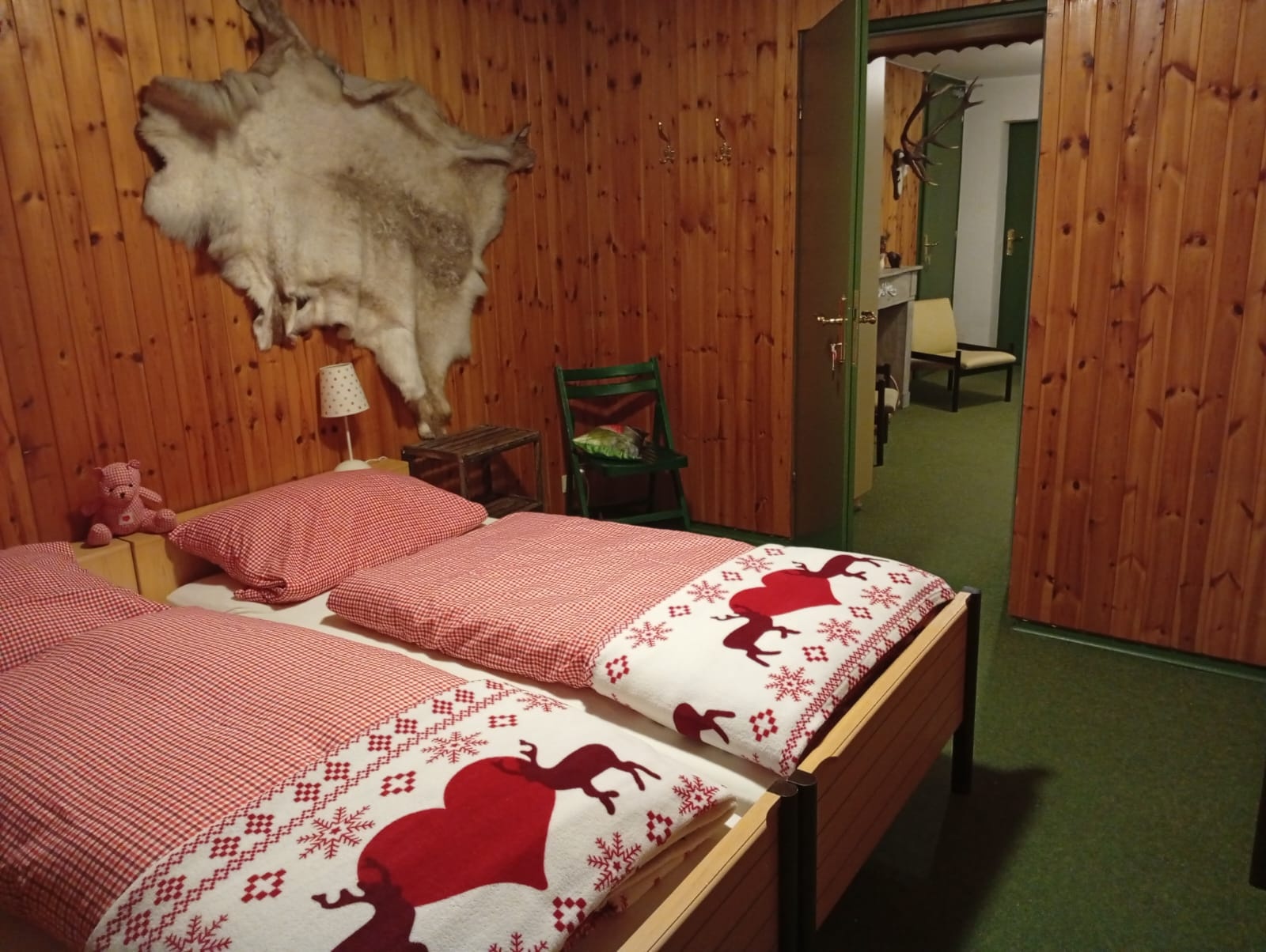 Schlafzimmer 2 im UG mit Doppelbett, Wandfell und Jagdhaus-Flair